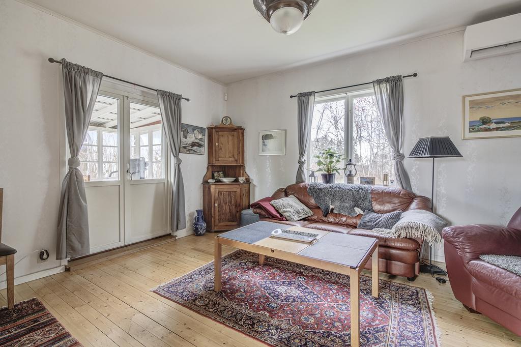 Vardagsrum med charmigt trägolv. Utgång till inglasad altan i skyddat läge. Ny luft/luft-värmepump installerad 2023.