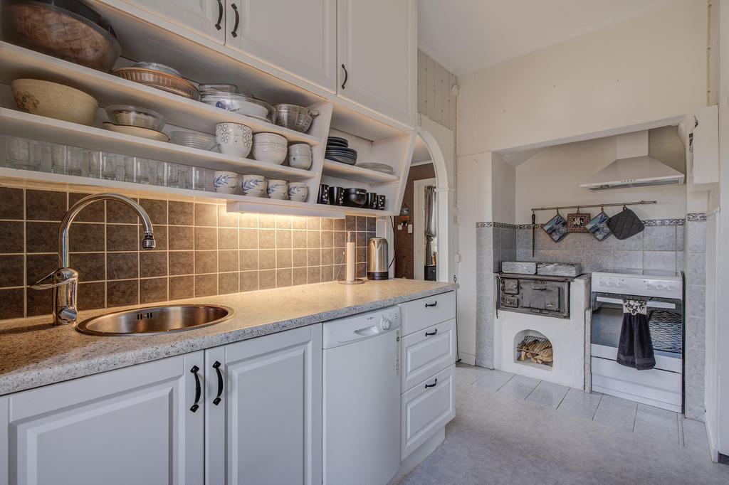 Charmigt kök varsamt renoverat med en härlig kombination av nya och äldre inslag. Spis, fläkt, diskmaskin, kombinerad kyl/frys och vedspis. Vit skåpinredning.