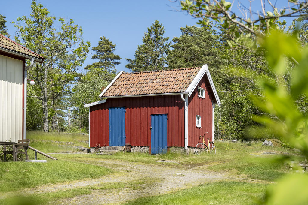 Uthus med vedförråd och plats för förvaring.
