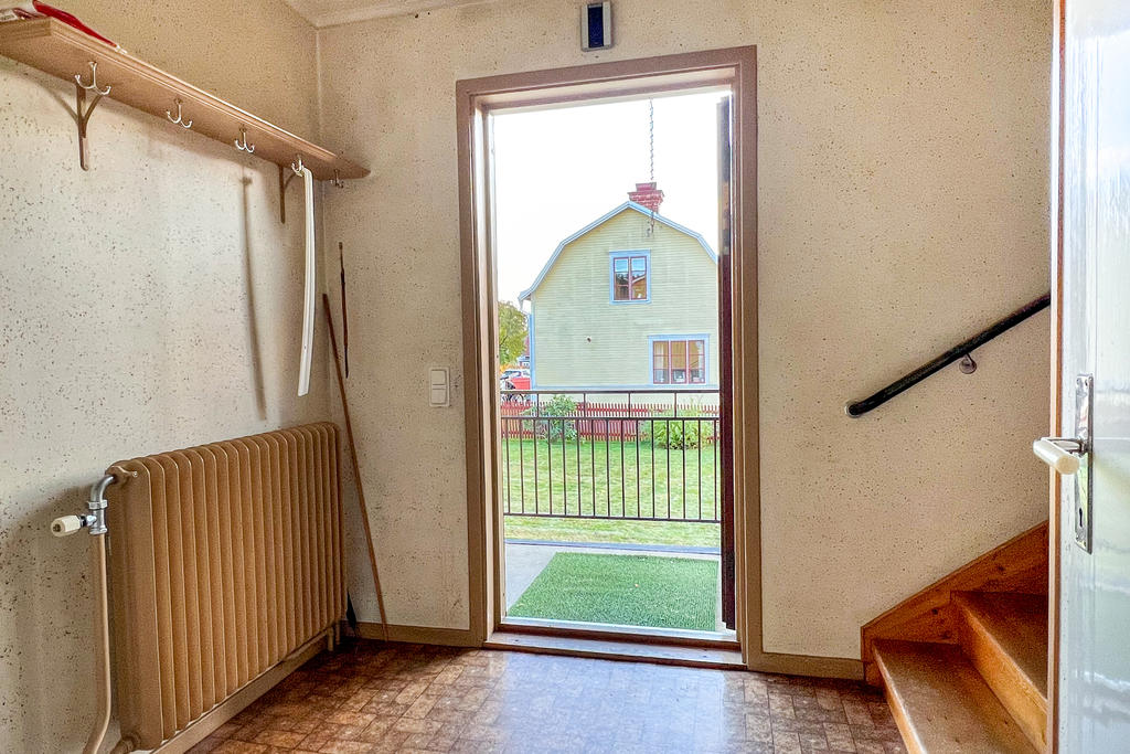 Hall med trapp till både övervåning och källaren