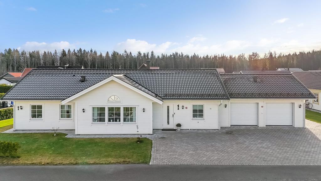 Ett vackert enplanshus med dubbelgarage och generös stenlagd uppfart