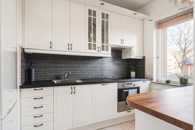 Hemtrevligt kök med vitrinskåp