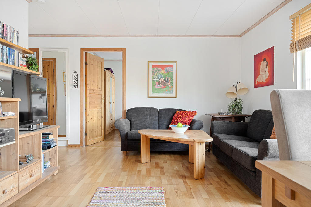 Vardagsrummet erbjuder en rymlig och social atmosfär med en öppen planlösning mot köket, perfekt för samvaro och umgänge. Direktutgång till terrassen i soligt sydvästläge finns även härifrån samt en värmande braskamin för extra värme och mysfaktor!