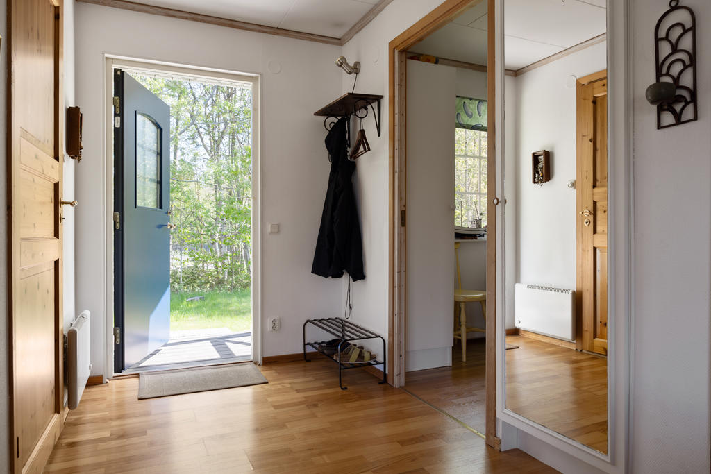 Den inbjudande hallen erbjuder praktiska avhängningsmöjligheter för ytterkläder och skor.
