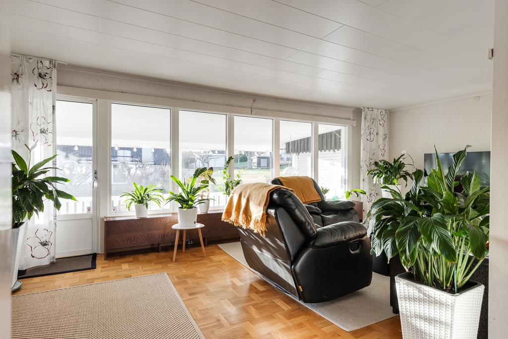 Vardagsrum med stavparkett och utgång till altan.