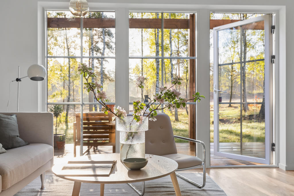 Stora fönsterpartier ner till golv i vardagsrummet ger ett härligt ljusinflöde på bostadens nedre plan. Inspirationsbild från visningshuset på Nässelvägen 6A (127 kvm).