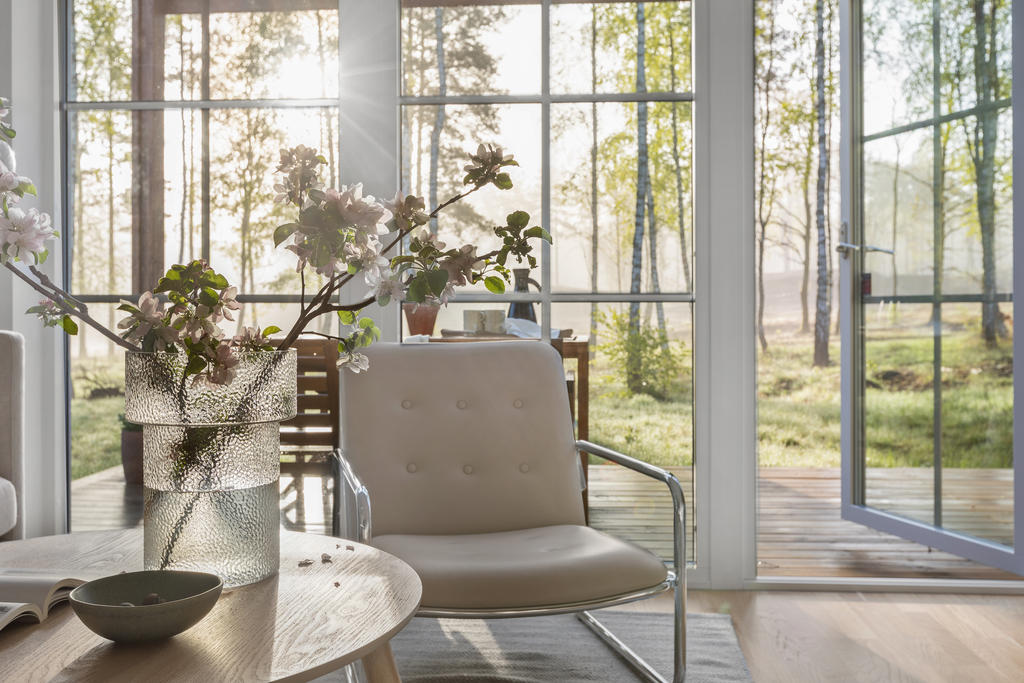 Stora fönsterpartier ner till golv i vardagsrummet ger ett härligt ljusinflöde på bostadens nedre plan. Inspirationsbild från visningshuset på Nässelvägen 6A (127 kvm).