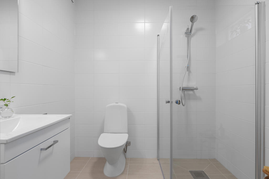 Helkaklat badrum med duschväggar i klarglas och praktiskt vädringsfönster. Inspirationsbild från visningshuset på Nässelvägen 6A (127 kvm).