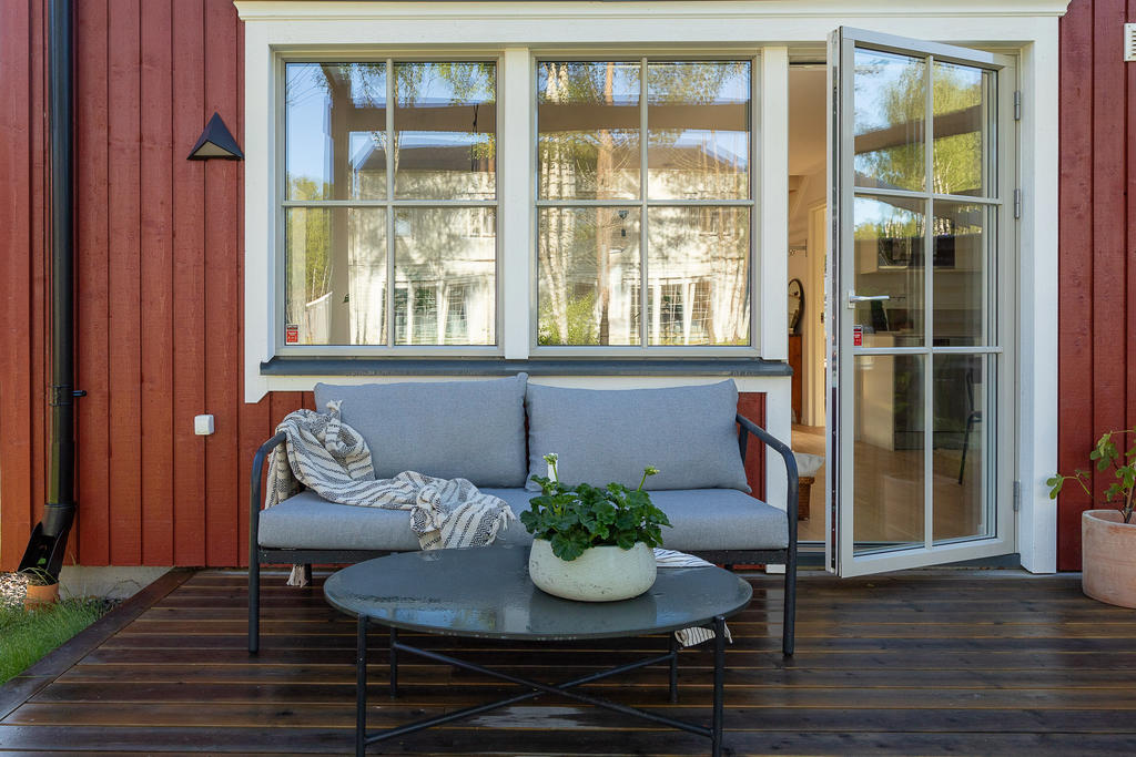 Från vardagsrummet kliver du ut på den större uteplatsen som ligger i anslutning till trädgården på husets baksida. Inspirationsbild från visningshuset på Nässelvägen 1A (101 kvm).