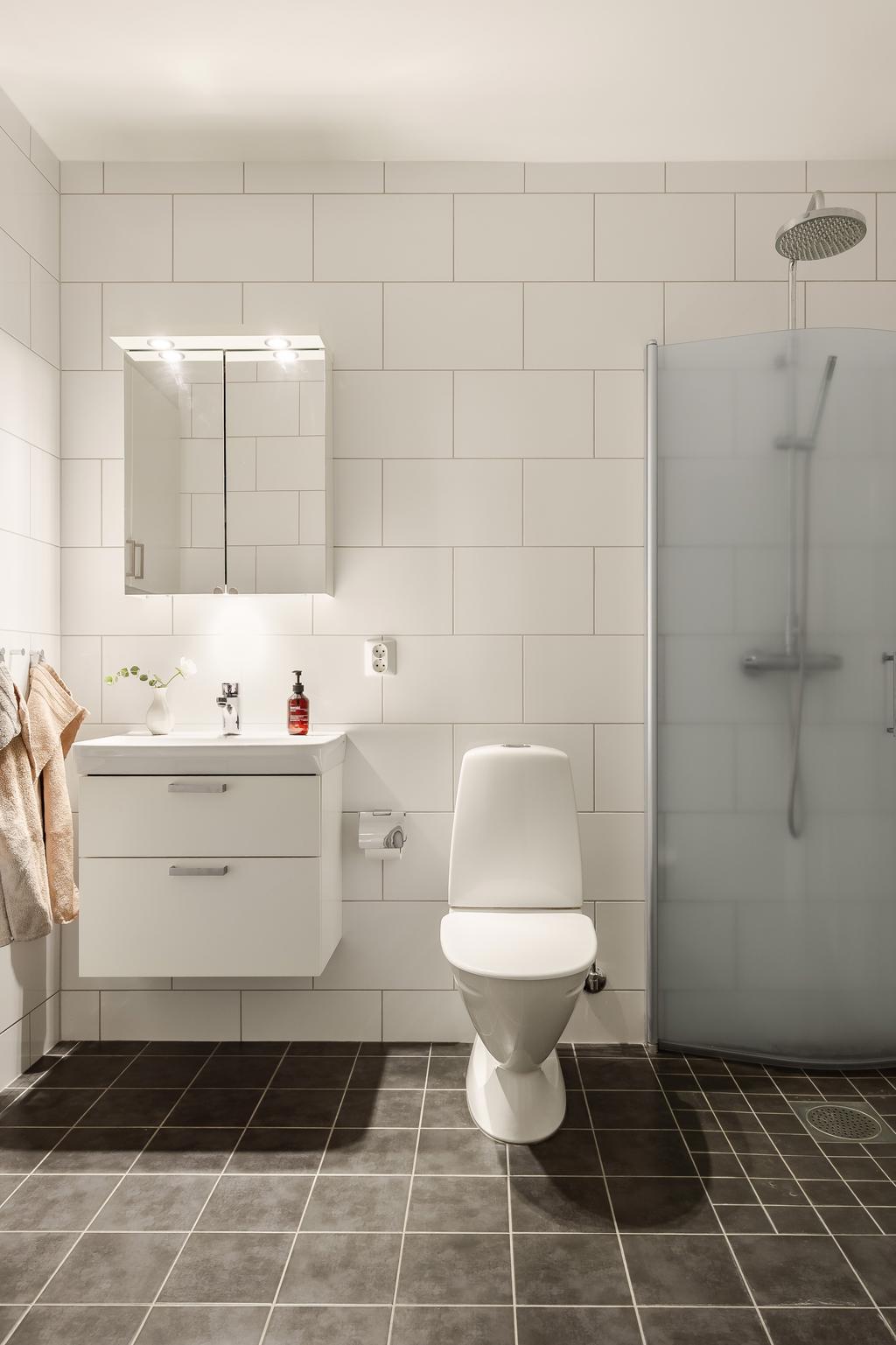 Badrummet är helkaklat i tidlöst grått och vitt.