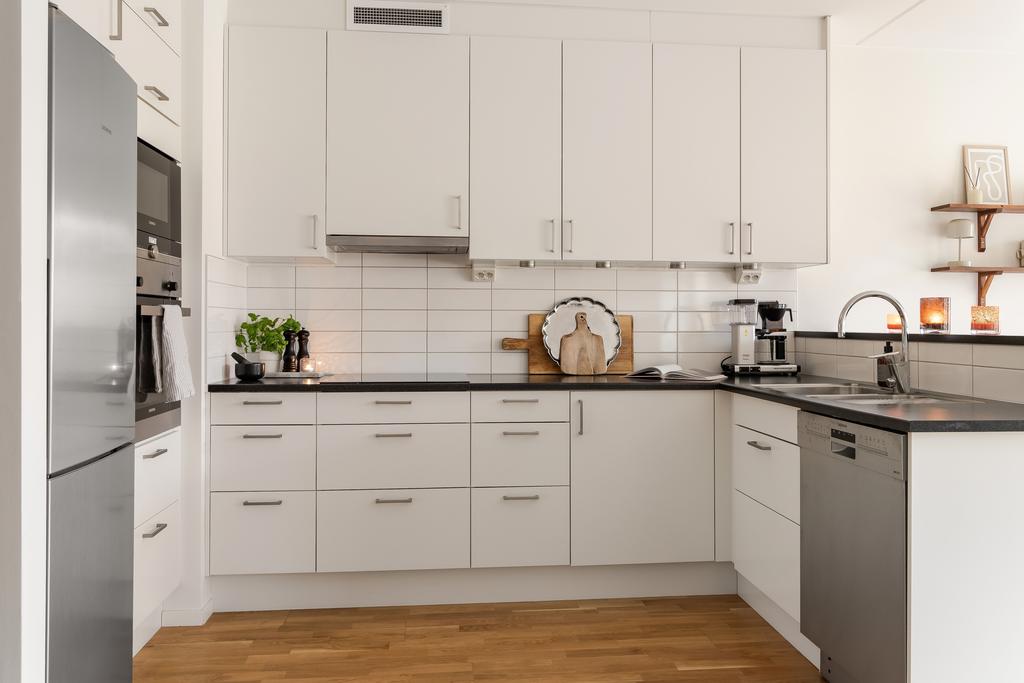 Ljust och stilrent kök med bra arbetsytor. Ugn och micro i bra arbetshöjd.