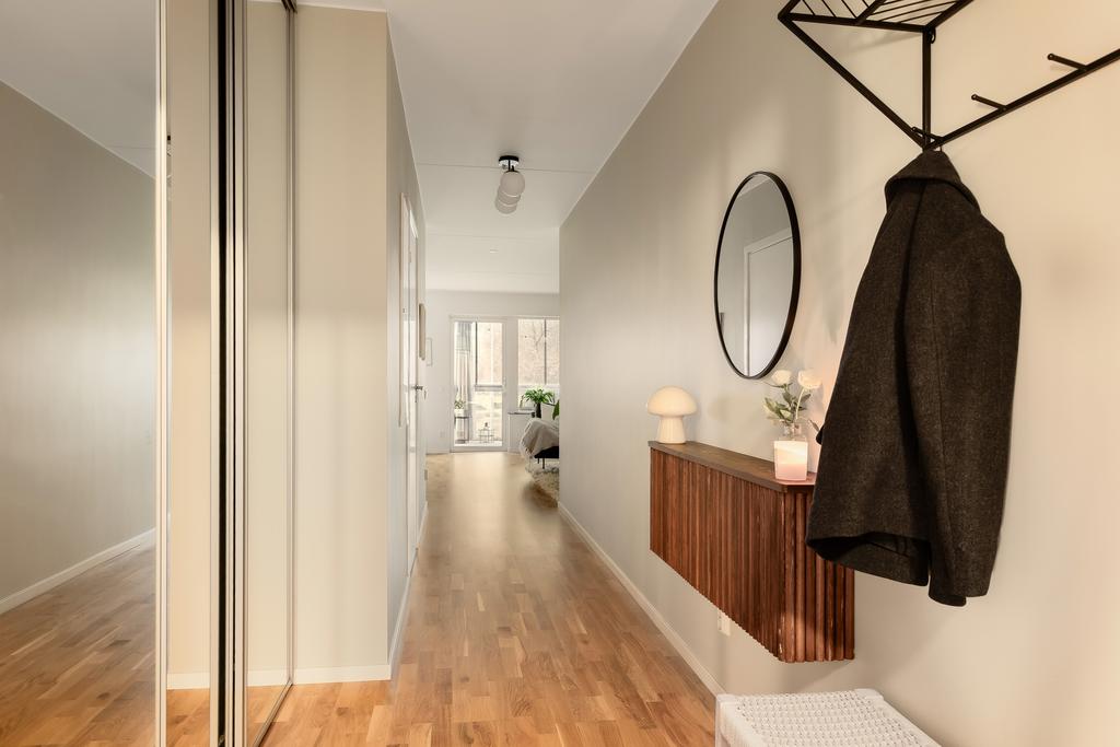 Direkt till vänster finns en stor garderob bakom skjutdörrar av spegel.