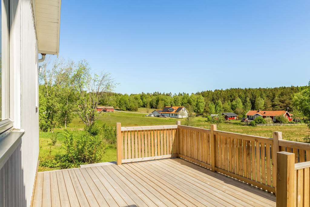 En härlig vy från altanen mot ängar och skog.