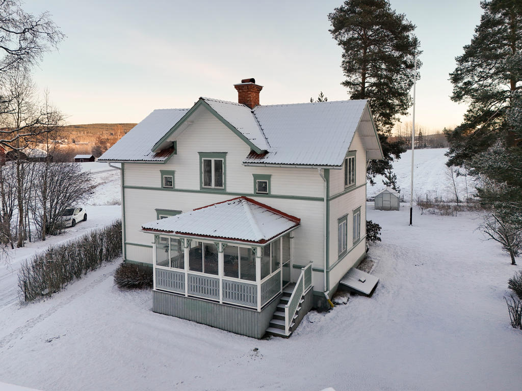 Fasad med inglasad altan i väster med kvällssol. 