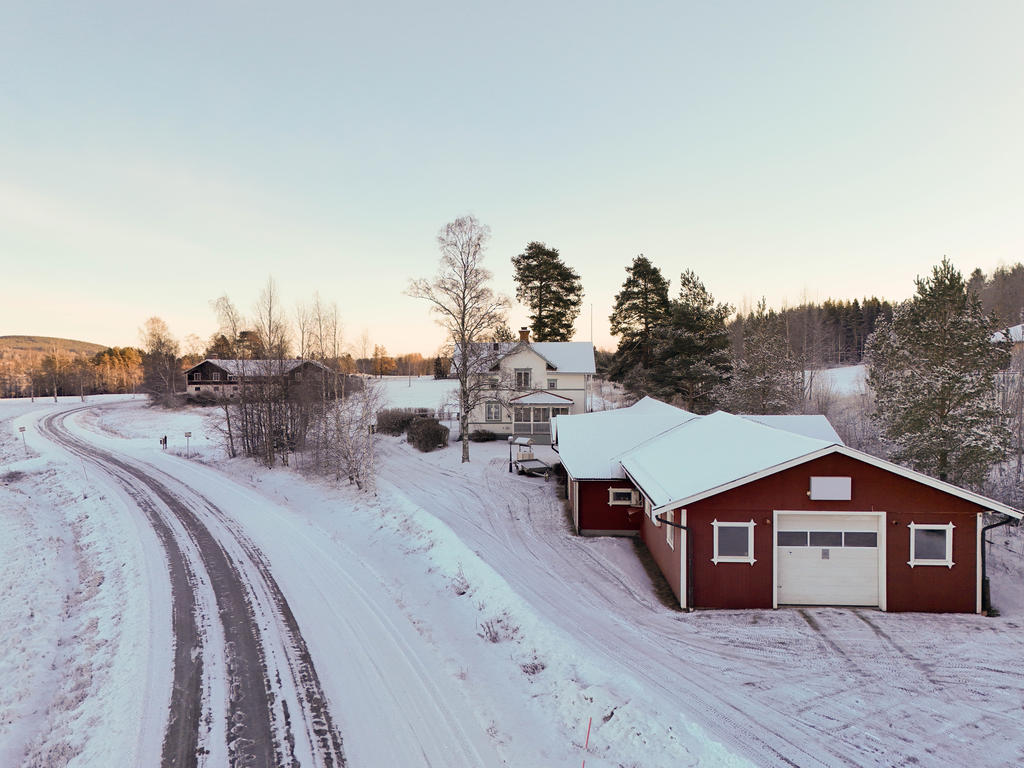 Vy över tomten med garage & verkstad och bostadshus samt Viksjöforsvägen som går förbi. 