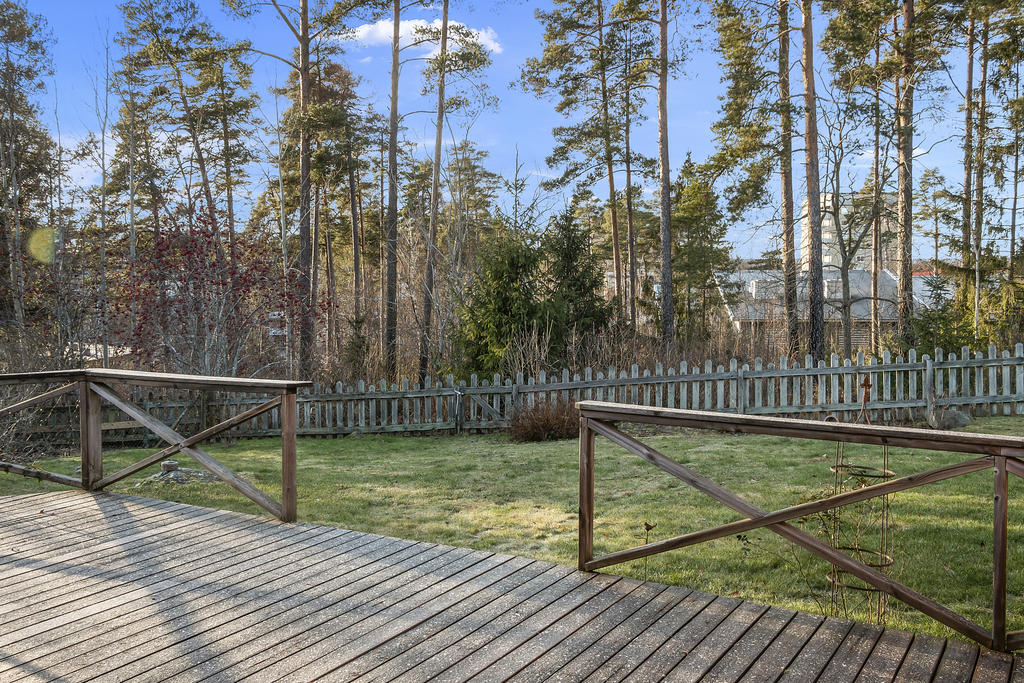 Uteplats och grönområden mot skogsdunge