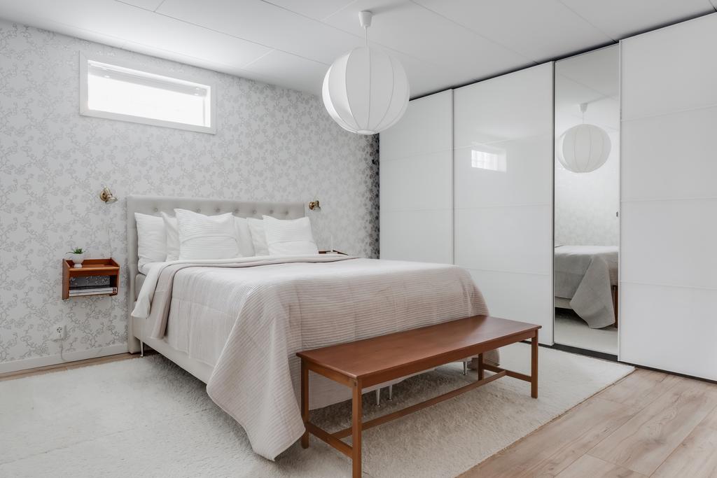 Master bedroom på entréplan med inbyggda garderober med skjutdörrar utmed hela en kortsidan