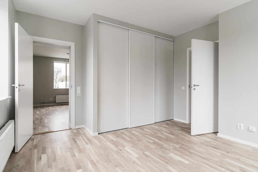 Sovrum med skjutdörrsgarderober.