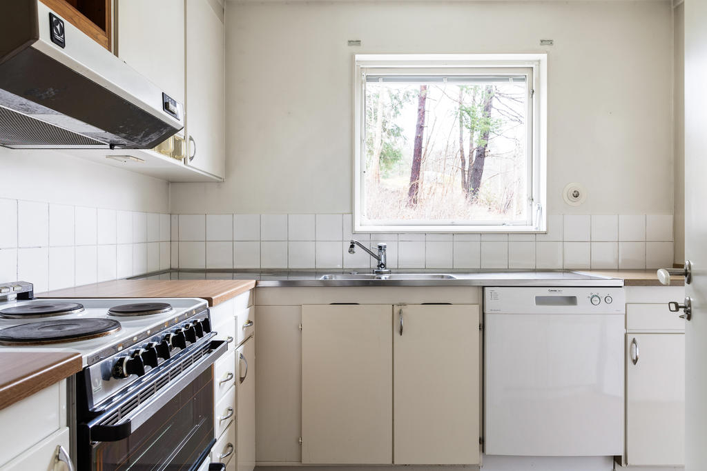Kök, med vy mot skogsdungen på baksidan av huset.