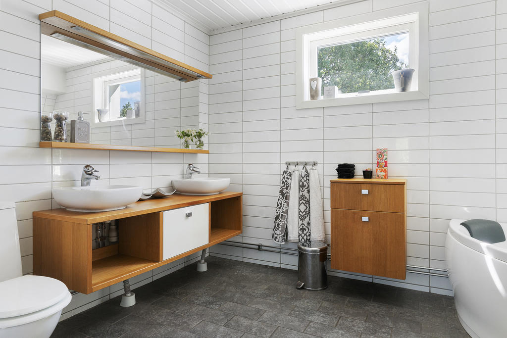 Rymligt och stilrent badrum med badkar och duschplats