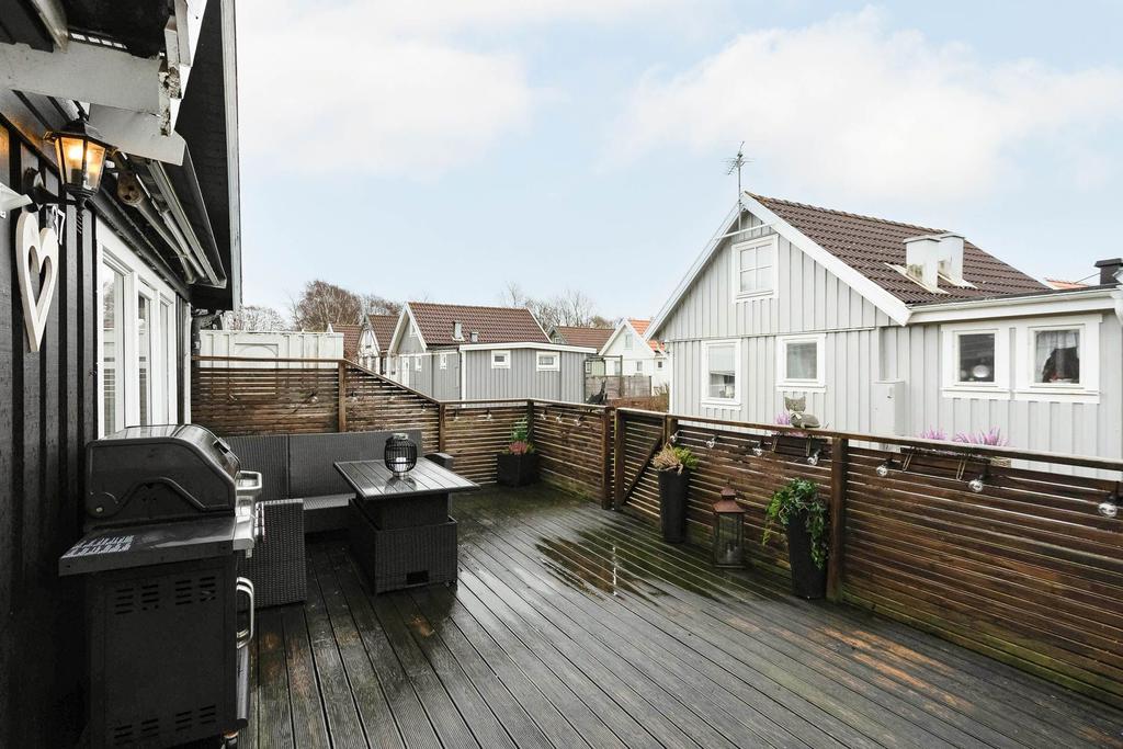 Rymligt trädäck med plats för både matgrupp och soffgrupp för den som önskar det