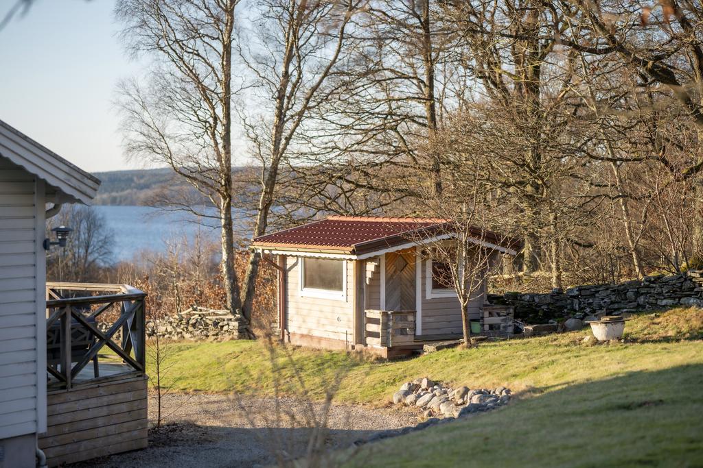 Friggebod med bastu i trädgården som är omgärdad av vackra stenmurar.