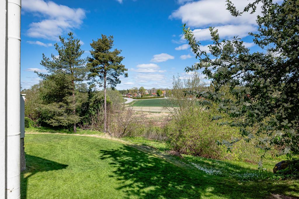 Genom häckarna på baksidan anas Åsa folkhögskola på andra sidan åkern