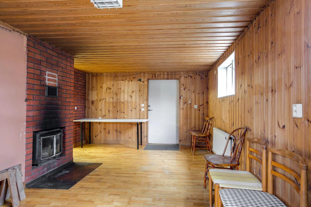 Stort sällskapsrum i källaren med öppen spis med insatskamin