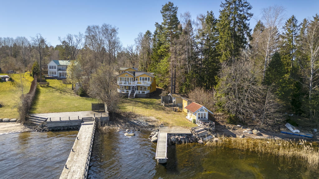 Huset sett från sjösidan. Bryggan är den mindre i bild till höger. Här ser man också sjöboden, en mindre redskapsbod samt friggebod