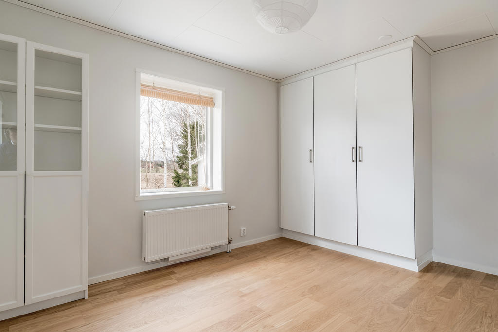 Sovrum 1 på nedre plan med garderober och ljusinsläpp från två väderstreck