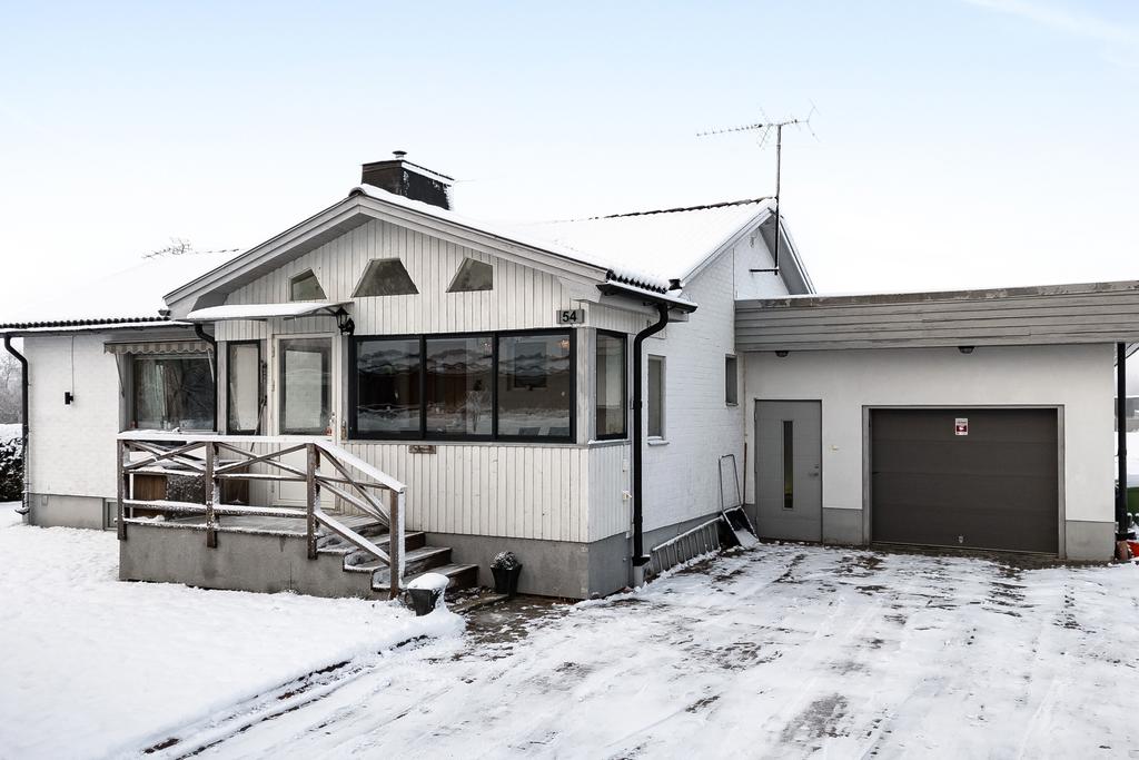 Bred uppfart och enkelgarage med smörjgrop. 