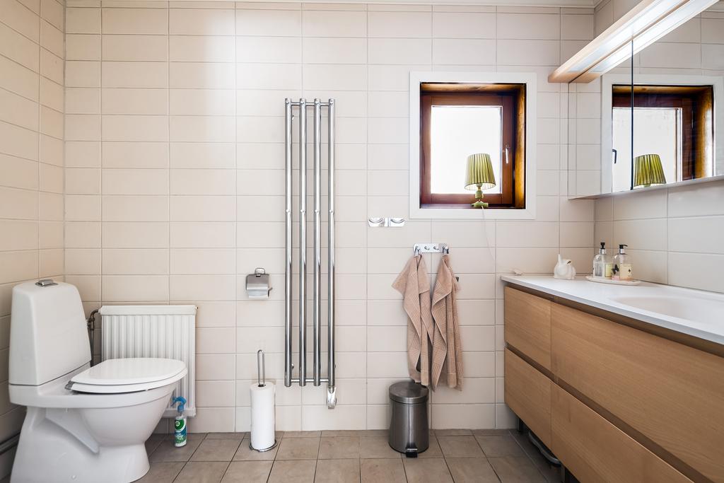 Badrummet på ovanvåningen har dusch, toalettstol, handukstork och kommod med handfat. 