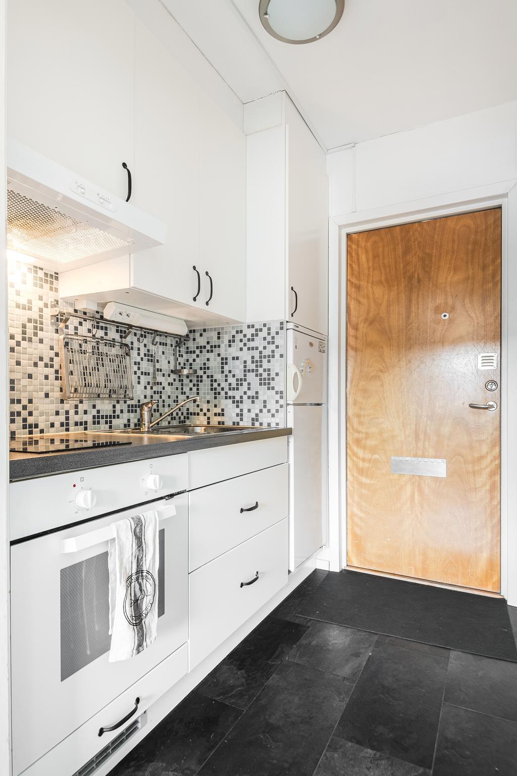 Kök med häll, ugn, fläkt, diskho och kyl med frys. 