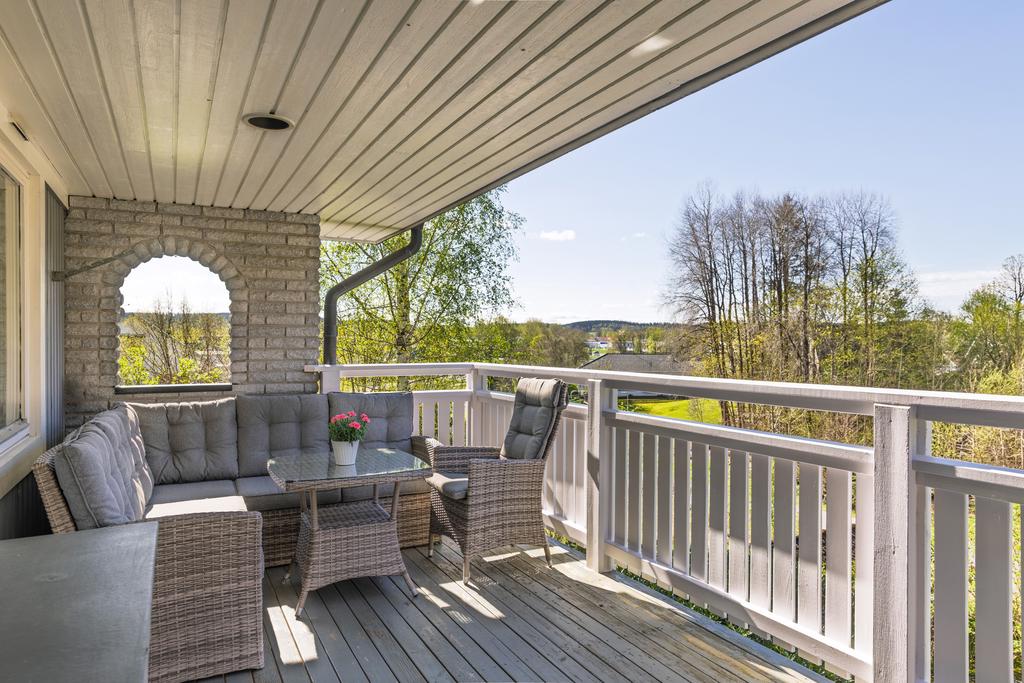 Stor balkong med tak och plats för både soffgrupp och matplats