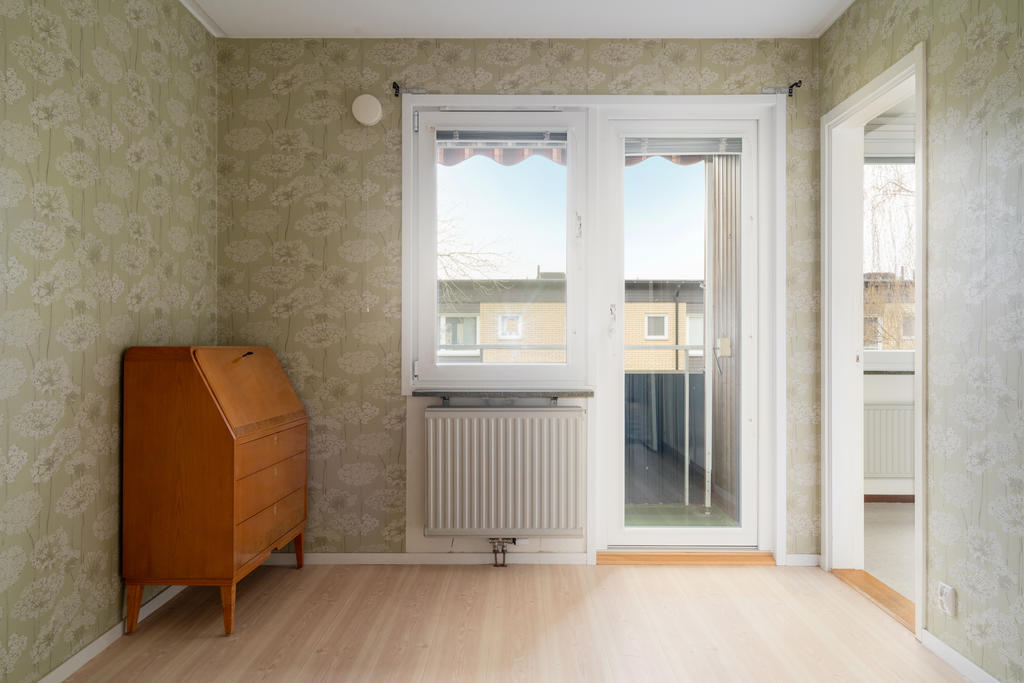 Sovrum med utgång till balkong och öppning mot kök