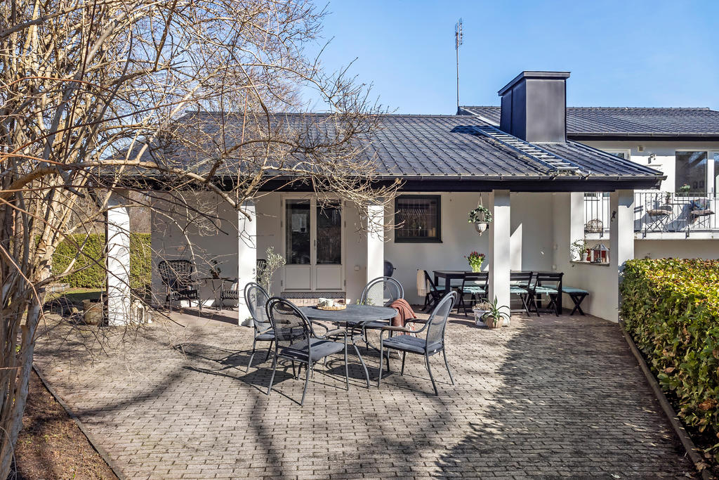 Stensatt uteplats, delvis under tak
