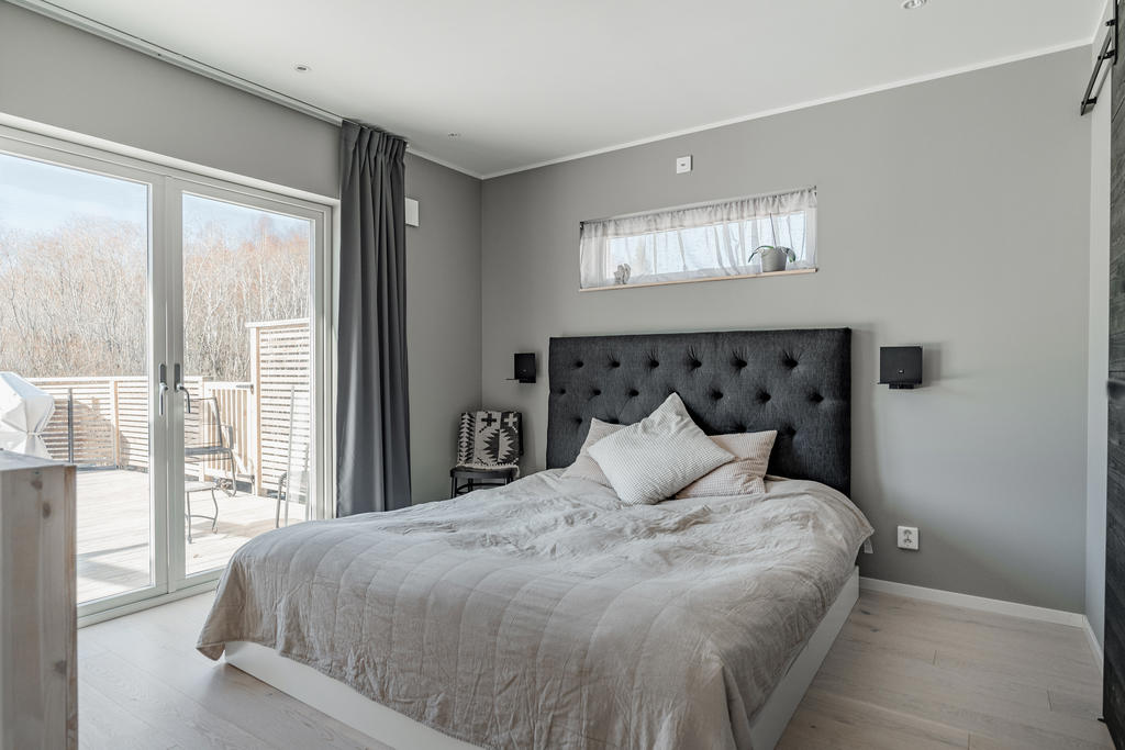 Master bedroom med eget badrum och klädkammare samt utgång till husets baksida.