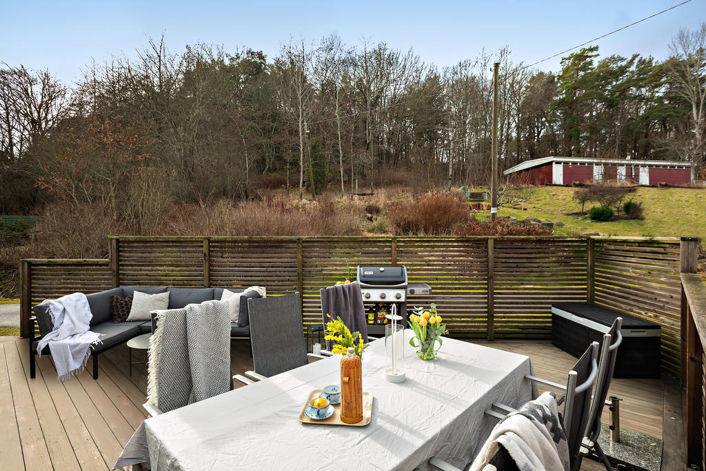 Stor altan med plats för soffgrupp, matbord, grill och solstolar
