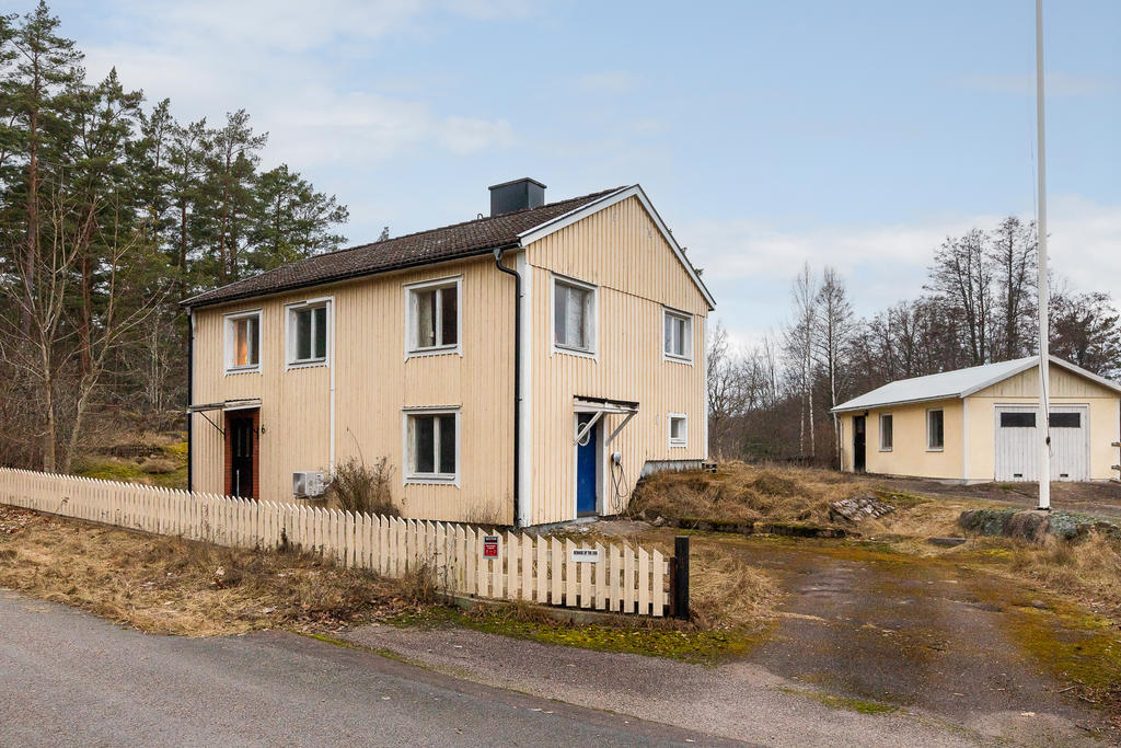 Fasadbild med garage och flaggstång