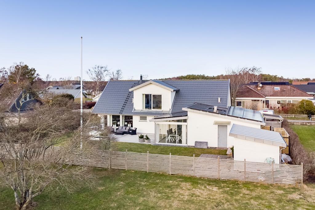 Lodjursvägen 8 från trädgårdssidan. Solceller ligger på garage och uterumstaket.