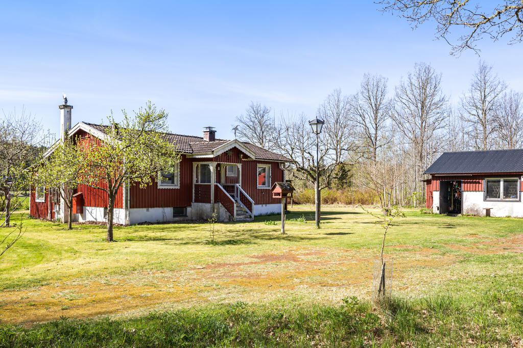 Gårdsplan med verkstaden skymtande till höger i bild.