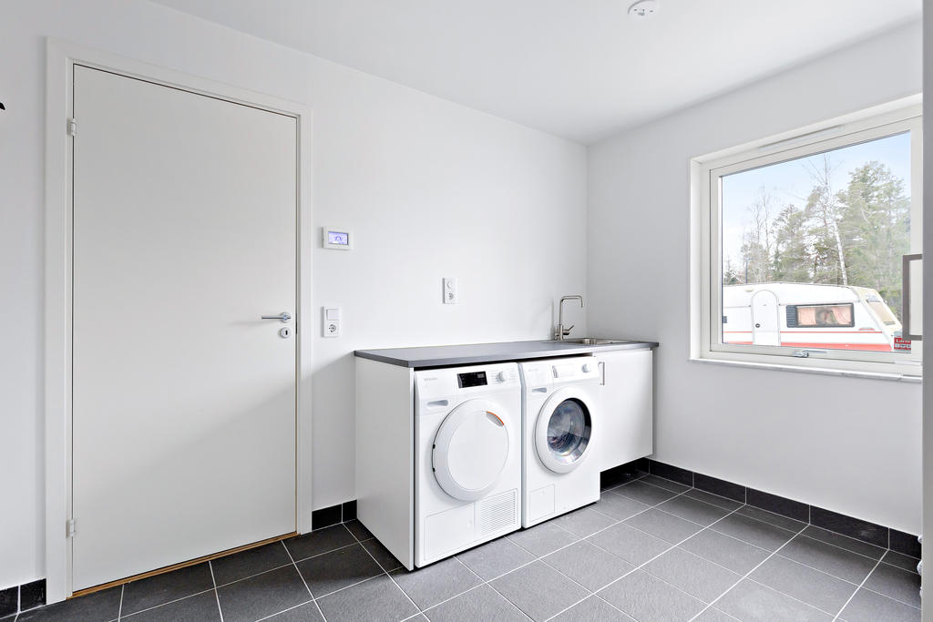 Tvättstuga med klinkers och arbetsbänk