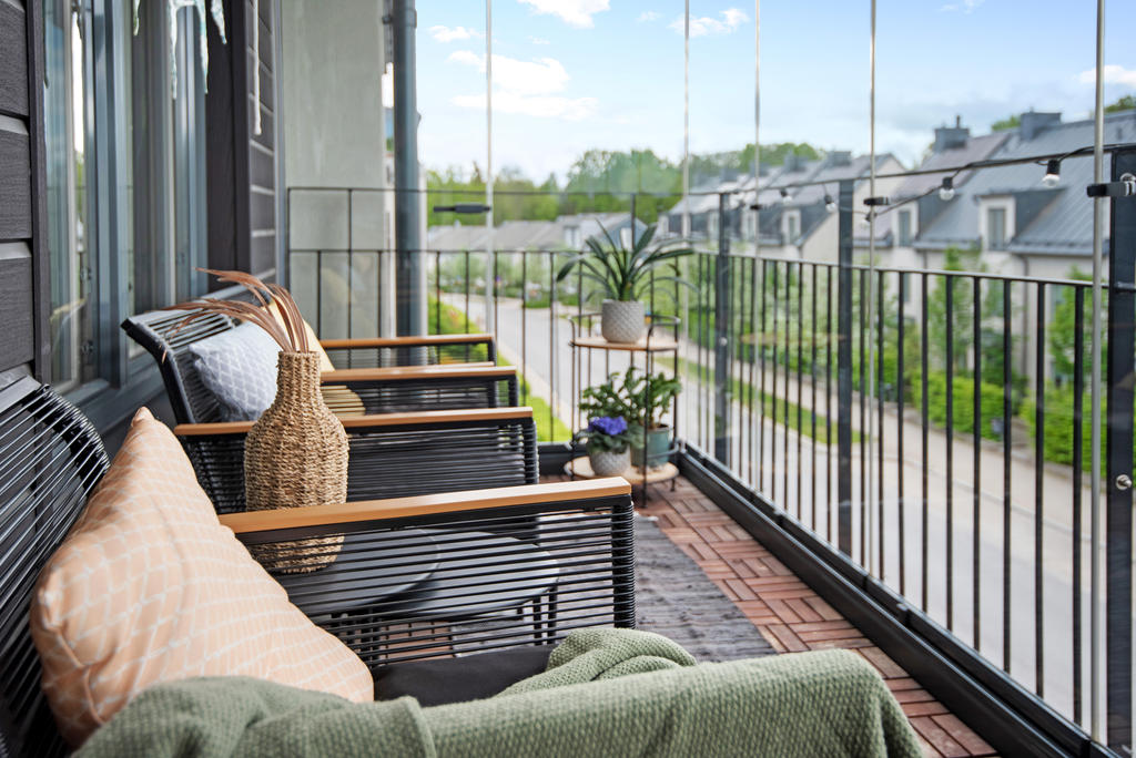 Stor inglasad balkong med kvällssol