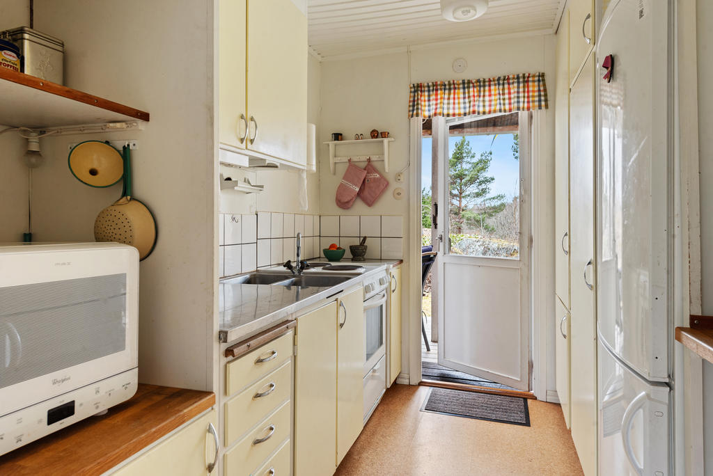 Det smart planerade arbetsköket har gott om förvaringsutrymme och en naturlig förbindelse till altanen, vilket gör det enkelt att ta med sig frukosten ut i morgonstunden. 