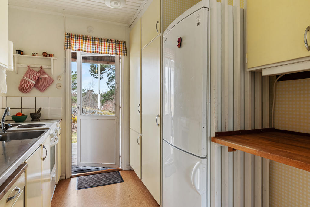 Det smart planerade arbetsköket har gott om förvaringsutrymme och en naturlig förbindelse till altanen, vilket gör det enkelt att ta med sig frukosten ut i morgonstunden. 