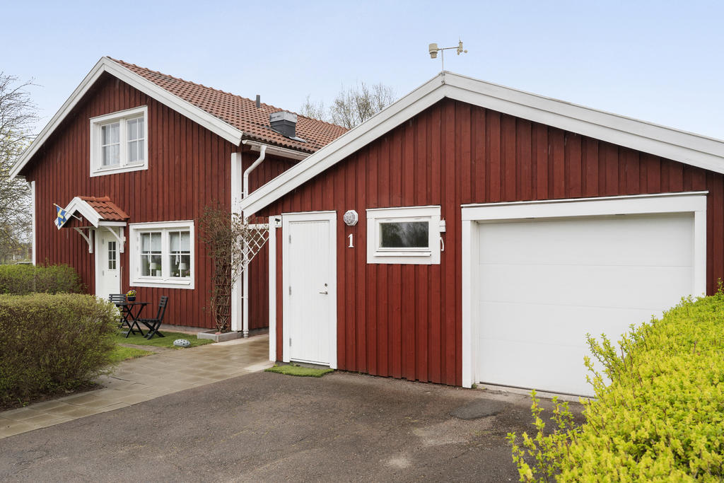 Uppfart framför huset med fristående garage. 