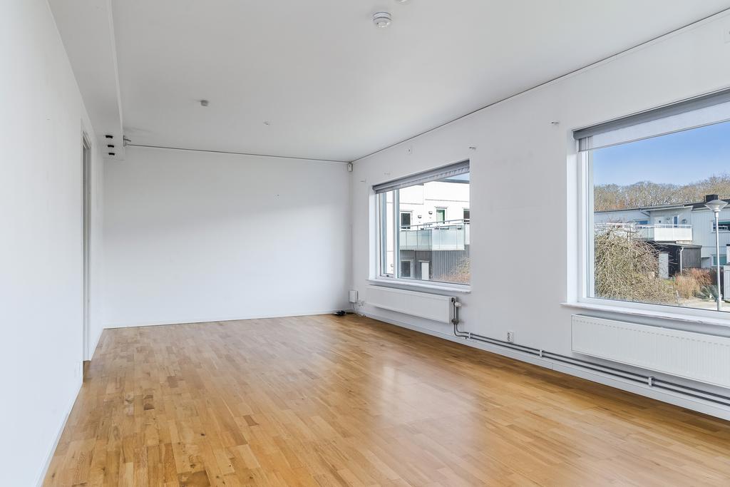 Vardagsrummet har stora fönsterpartier mot föreningen innergård