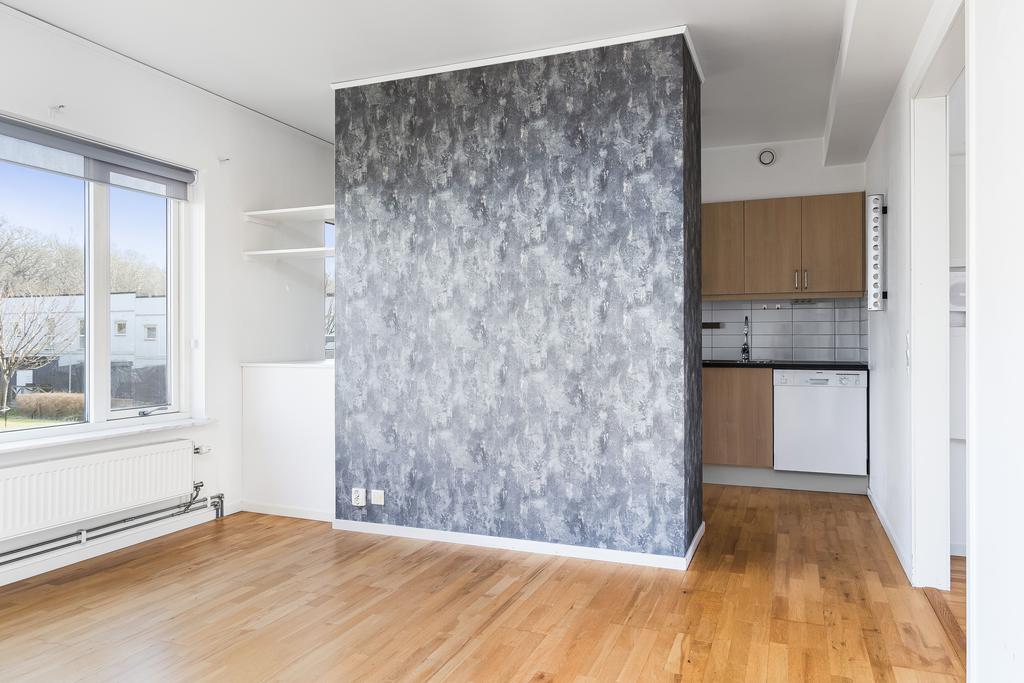 Här finns det en vägg som praktiskt skärmar av köket och vardagsrummet till viss del