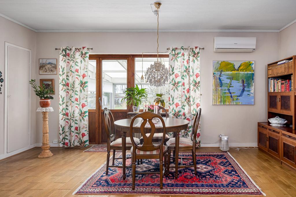 Elegant matsalsdel i anslutning till vardagsrummet, perfekt för både vardagsmåltider och festliga tillfällen. På golvet ligger ett fin träparkett.