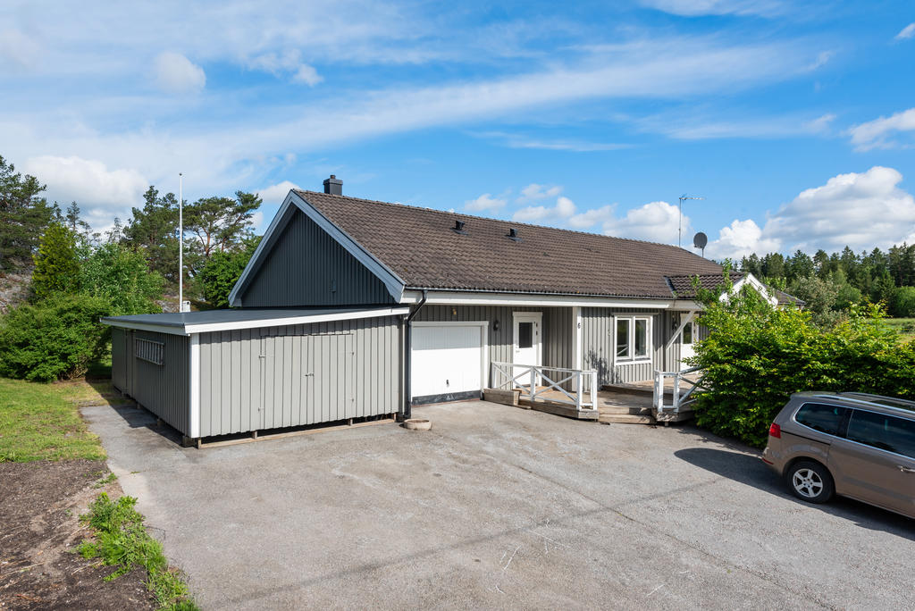 Asfalterad uppfart med plats för flertalet bilar samt garage och vidbyggt förråd. 
